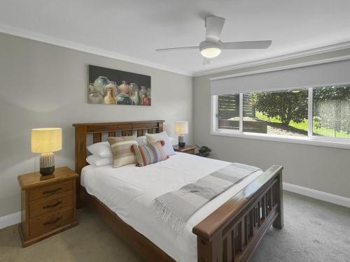 una camera da letto con un letto grande e una finestra di The Nest by Batemans Bay a Batemans Bay