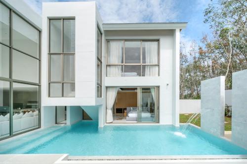 a house with a swimming pool in front of it at Brand New & Modern Luxury 4BR Pool Villa in Residence Lux Pride 2 V12 in Bang Tao Beach