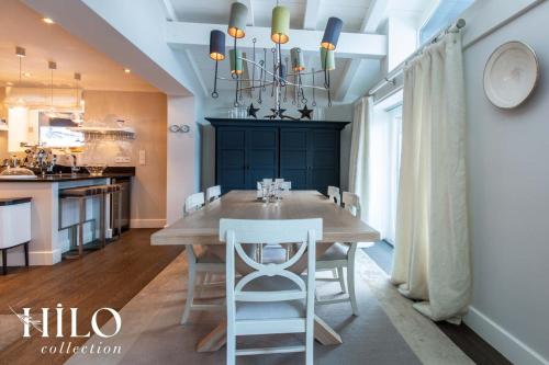 une cuisine et une salle à manger avec une table et des chaises en bois dans l'établissement HILO Cottage Chamonix Mont Blanc La Moraine, à Chamonix-Mont-Blanc