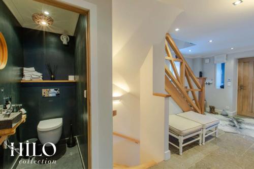 ein Badezimmer mit einem Waschbecken, einem WC und einer Treppe in der Unterkunft Chalet La Moraine Chamonix Mont Blanc by HILO Collection - 8 people - Jacuzzi and PS5 in Chamonix-Mont-Blanc