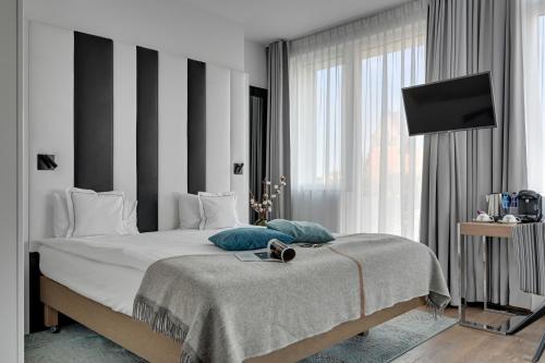 a bedroom with a large bed and a television at HOTEL ALMOND BUSINESS & SPA BY GRANO - GRANO HOTEL Gdańsk Riverside in Gdańsk
