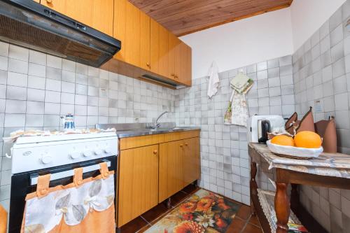 a kitchen with a stove and a bowl of oranges at Holiday Home Tommaso e Martina in Savoca 
