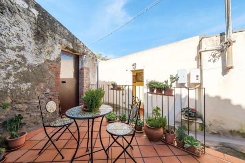 a patio with two tables and potted plants at Holiday Home Tommaso e Martina in Savoca 