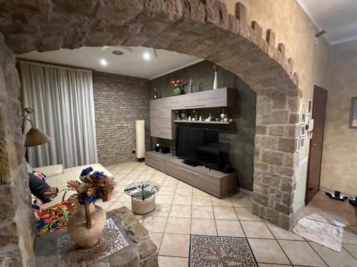 a living room with a stone fireplace and a television at Il Tortellino Quasi in Centro Elegant Apartment in Modena