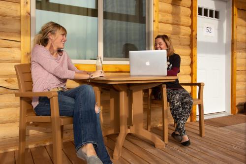 two women sitting at a table with a laptop at Young's Motel in Tok