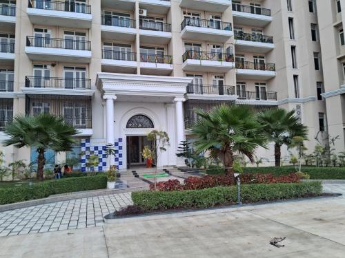a building with palm trees in front of it at omaxe hi tech city 2nd home infront of triveni sangam in Prayagraj