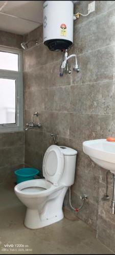 a bathroom with a toilet and a sink at omaxe hi tech city 2nd home infront of triveni sangam in Prayagraj