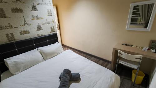 a bedroom with a bed with a pair of shoes on it at Natol Homestay - LA Tabuan Jaya in Kuching