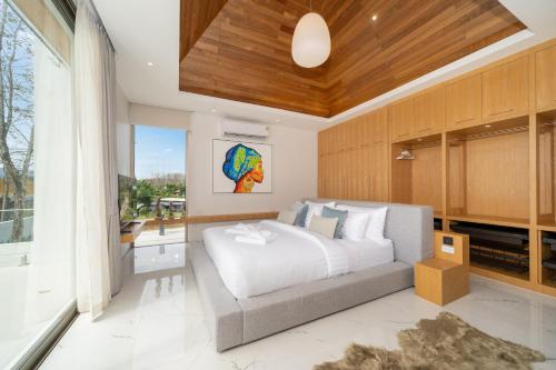 Ban Pak LakにあるBrand New & Modern Luxury 4BR Pool Villa in Residence Lux Pride 2 V12の白いベッドと大きな窓のある寝室
