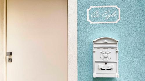 a blue wall with a white mailbox next to a door at Ca' Egle by Ca-Sa Check in Chioggia