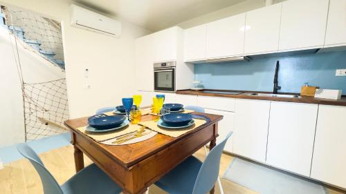 a kitchen with a wooden table with blue chairs at Ca' Egle by Ca-Sa Check in Chioggia
