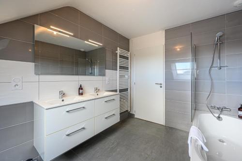 a bathroom with two sinks and a shower and a tub at Domaine de Larmor - Maison proche plages in Damgan