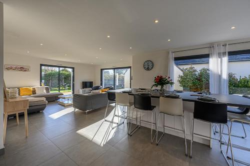 Il comprend une cuisine et un salon avec un bar et des chaises. dans l'établissement Domaine de Larmor - Maison proche plages, à Damgan