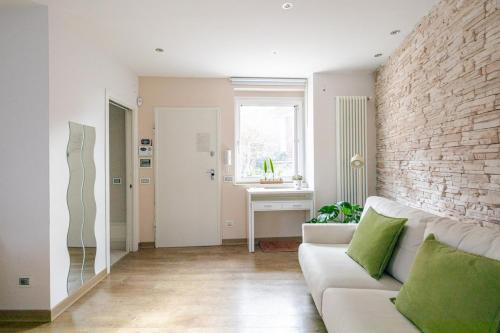 a living room with a white couch and a brick wall at Laura Blu Charme Casa rilassante Lago di Bolsena in Valentano