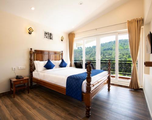 科塔吉里COASTAL GRAND RESORT - KOTAGIRI的一间带床和大窗户的卧室