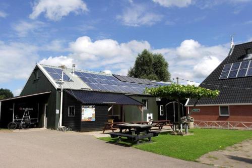 a barn with solar panels on the roof at Zilveren maan blokhut 2, trekkershut 2 in De Valom