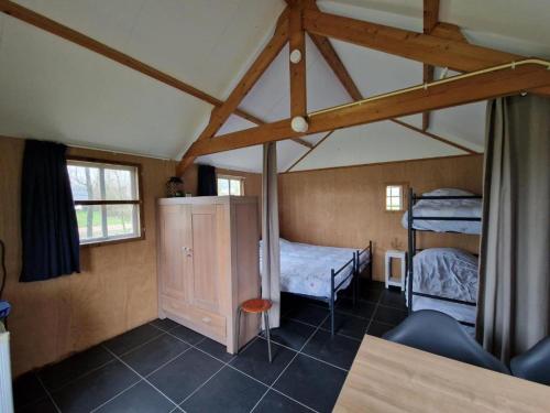 a room with two bunk beds in a attic at Zilveren maan blokhut 2, trekkershut 2 in De Valom