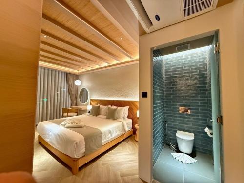 a bedroom with a bed and a bathroom with a shower at Baan Tah On The Sea in Bang Sare