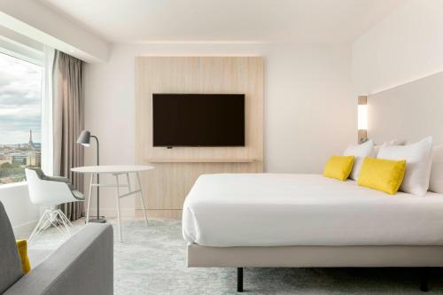 a hotel room with a bed and a flat screen tv at Courtyard by Marriott Paris Gare de Lyon in Paris