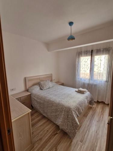 a small bedroom with a bed and a window at El peromato in Zamora