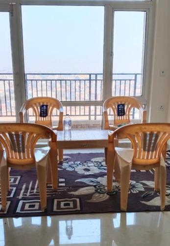 a table and chairs in a room with a balcony at omaxe hi tech city 2nd home infront of triveni sangam in Prayagraj