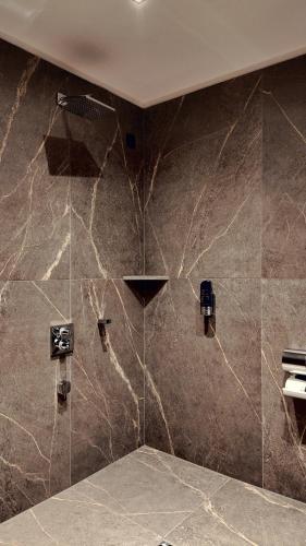 a bathroom with a shower with a stone wall at Bellman Hotel in Berlin