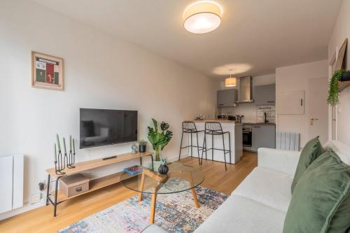 un salon avec un canapé blanc et une télévision dans l'établissement Appartement une chambre avec parking et balcons, à Tourcoing