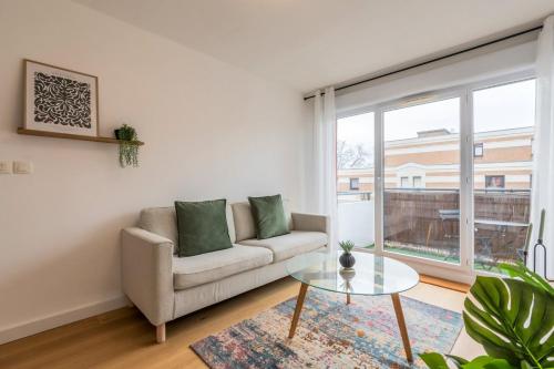 Una sala de estar con un sofá y una mesa de cristal. en Appartement une chambre avec parking et balcons, en Tourcoing