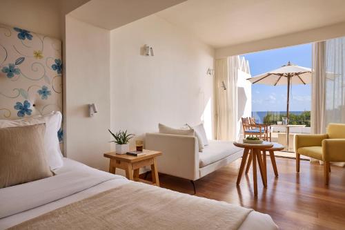 a bedroom with a bed and a living room at St. Nicolas Bay Resort Hotel & Villas in Agios Nikolaos