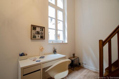 un bureau avec un bureau et une fenêtre dans l'établissement Studio calme hypercentre - Ty ar Lafayette, à Rennes