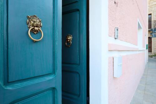a blue door with a gold knocker on it at Luxury studio Garibaldi - perfect for couples - fully Equipped - Historical Centre in Olbia