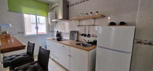 kuchnia z białą lodówką i zlewem w obiekcie apartamento céntrico jerez calle tucan n17 w mieście Jerez de la Frontera