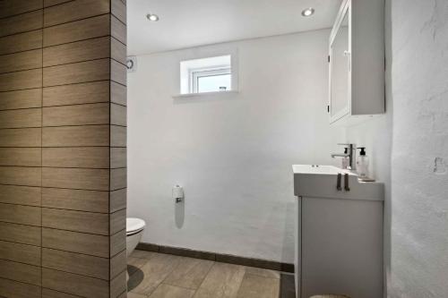a white bathroom with a toilet and a sink at Large Holiday Home By The Limfjord in Thyholm