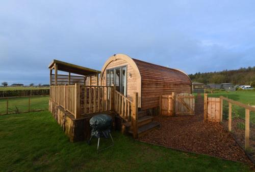 a small wooden cabin with stairs and a porch at The Galloway Steading - The Herons Nest, secure garden and with Hot Tub and Fire Pit in Glenluce