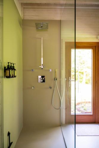 a bathroom with a shower with a glass door at ZenCabin - Luxe en Wellness in de natuur in Hulshout