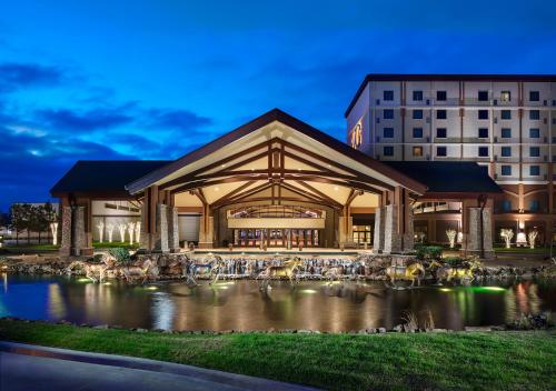 un edificio con un estanque frente a un edificio en Choctaw Casino Hotel – Pocola, en Pocola