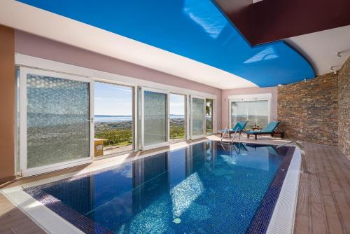 斯普利特Villa Awesome的一个带蓝色天花板和窗户的室内游泳池