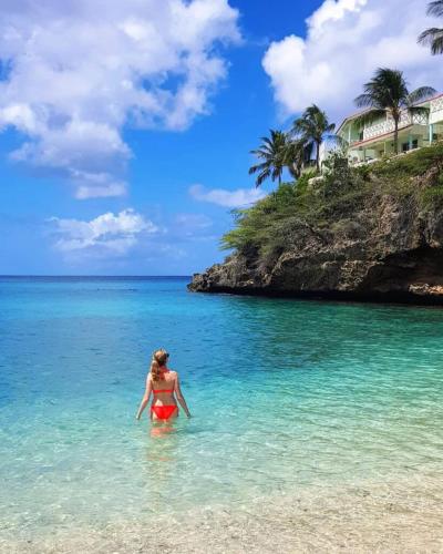 a woman standing in the water on a beach at Apartment "Always SUNday", Lagoon Ocean Resort in Lagun