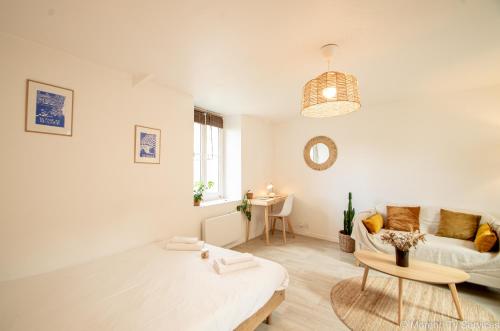 un salon blanc avec un canapé et une table dans l'établissement Studio calme et cosy avec parking - Ty ar Gwilen, à Rennes