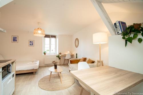un salon avec un canapé et une table dans l'établissement Studio calme et cosy avec parking - Ty ar Gwilen, à Rennes