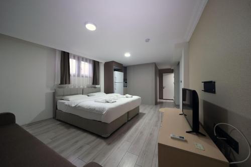 a bedroom with a bed and a desk with a television at Lacasita Urla in Urla