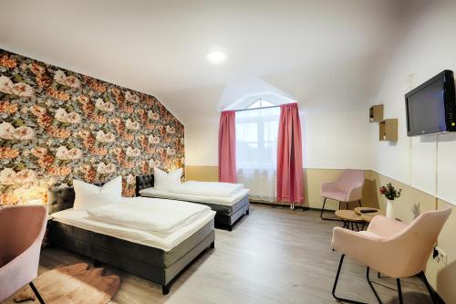 a hotel room with two beds and a tv at Hotel Apfelblüte in Wendorf
