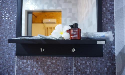 a bathroom counter with a mirror and a bottle of shampoo at TinyHouse at TigerCave in Ko Bu Bu