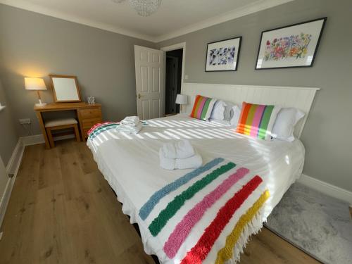 a bedroom with a large white bed with towels on it at Vast, Elegant Home with Indoor Pool & Sauna near Popular Golf Course in Kington