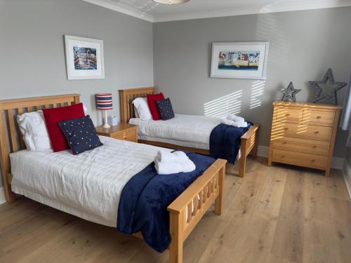 a bedroom with two beds and a dresser at Vast, Elegant Home with Indoor Pool & Sauna near Popular Golf Course in Kington