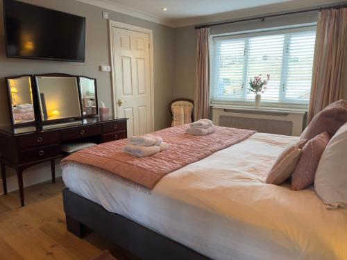 a bedroom with a large bed with towels on it at Vast, Elegant Home with Indoor Pool & Sauna near Popular Golf Course in Kington