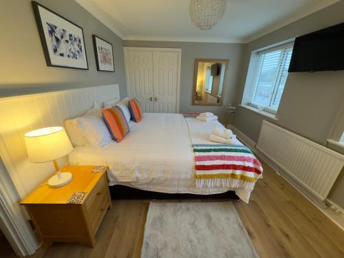 a bedroom with a bed and a table with a lamp at Vast, Elegant Home with Indoor Pool & Sauna near Popular Golf Course in Kington
