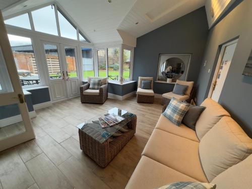 a living room with a couch and chairs and a table at Vast, Elegant Home with Indoor Pool & Sauna near Popular Golf Course in Kington