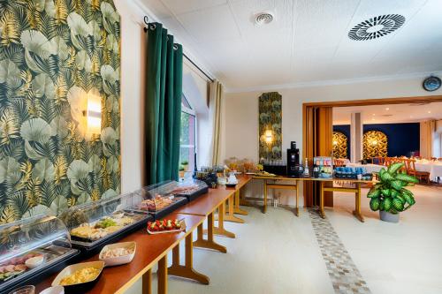 a restaurant with long tables with food on them at Hotel Apfelblüte in Wendorf