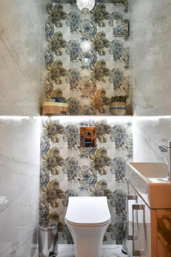 a bathroom with a toilet and a floral wallpaper at Апартамент Девио Чар in Ruse